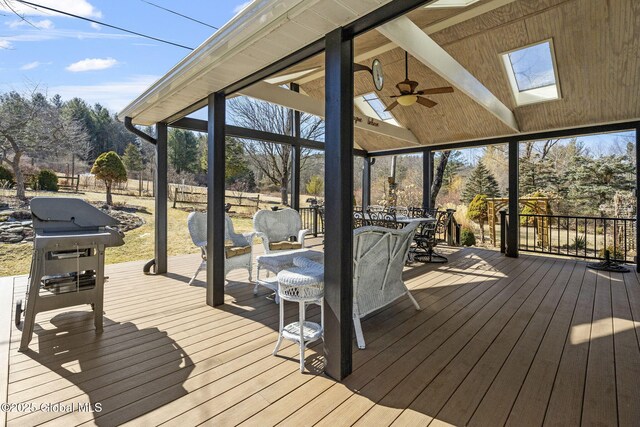 wooden deck with outdoor dining area, ceiling fan, area for grilling, and fence