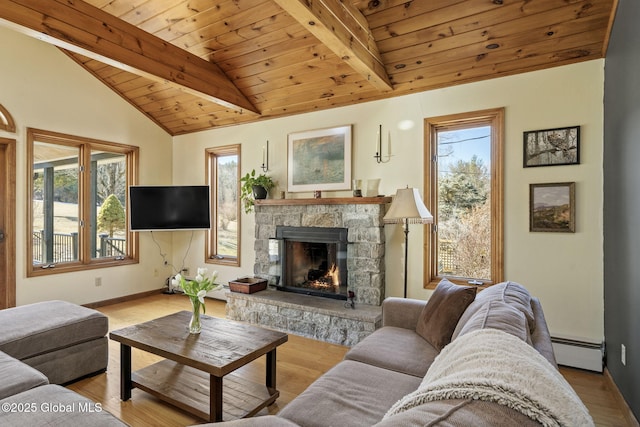 living area featuring lofted ceiling with beams, a baseboard heating unit, a stone fireplace, wood finished floors, and wooden ceiling