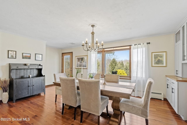 dining area with a notable chandelier, a baseboard radiator, hardwood / wood-style flooring, and crown molding