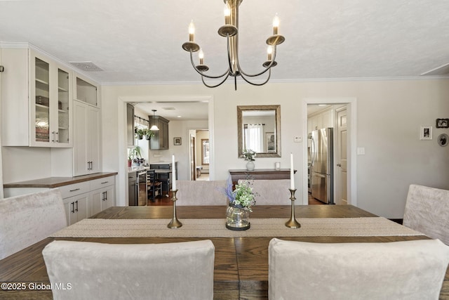 dining room featuring visible vents, dark wood-type flooring, and crown molding