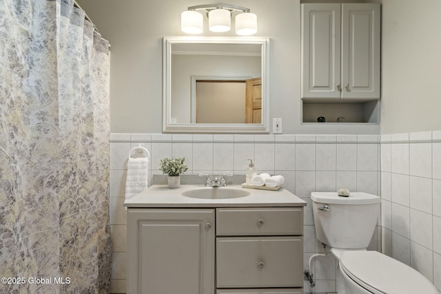 full bath with vanity, toilet, and tile walls