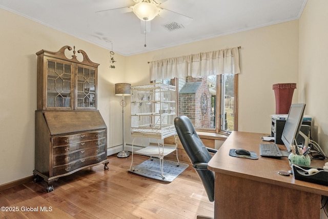 office area featuring a baseboard radiator, wood finished floors, visible vents, a ceiling fan, and ornamental molding