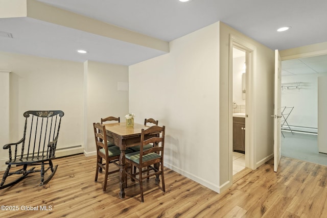 dining space with baseboards, light wood-type flooring, a baseboard radiator, and recessed lighting