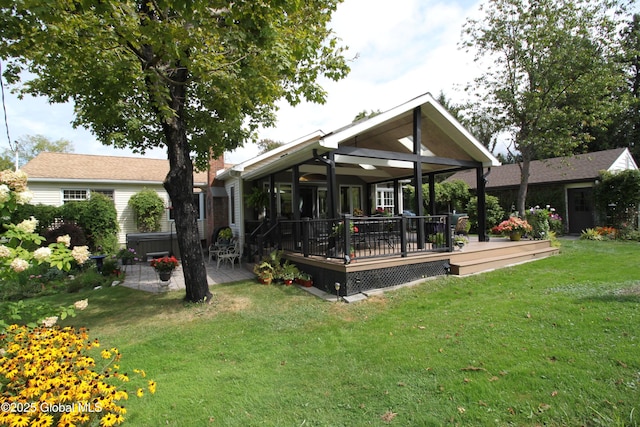 rear view of house featuring a yard and a wooden deck