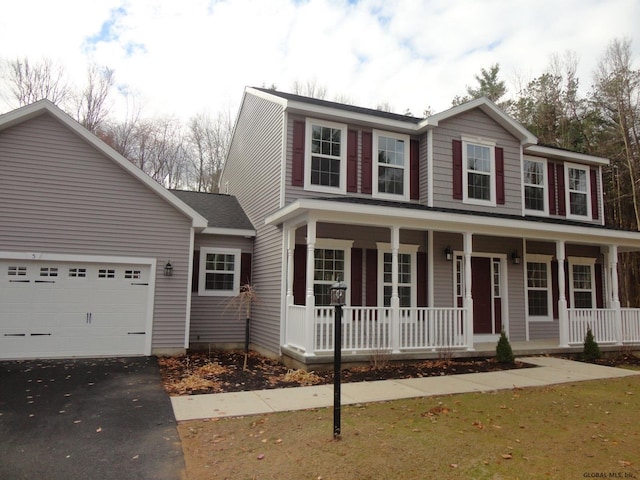 view of front of home featuring a garage, a porch, and aphalt driveway