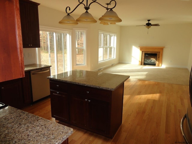 kitchen featuring a fireplace, dishwasher, light wood-style flooring, and a ceiling fan