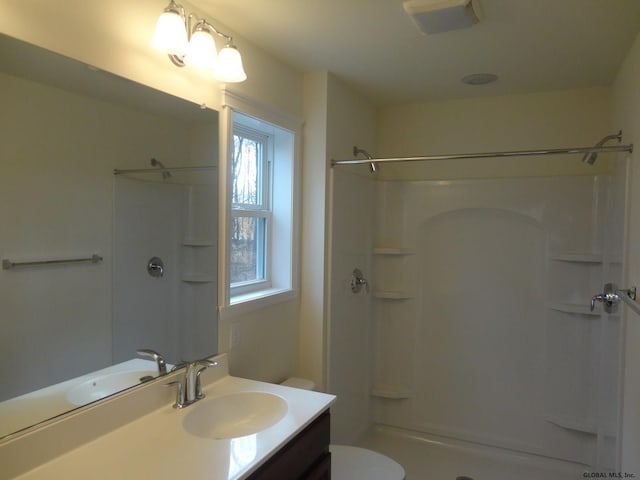 full bathroom with vanity, toilet, and a stall shower