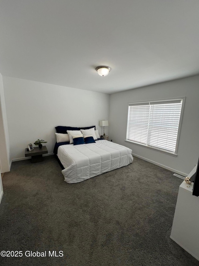 bedroom with baseboards and dark colored carpet