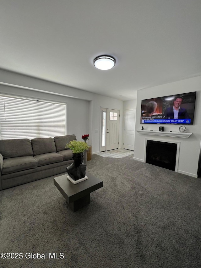 carpeted living area featuring a fireplace and baseboards