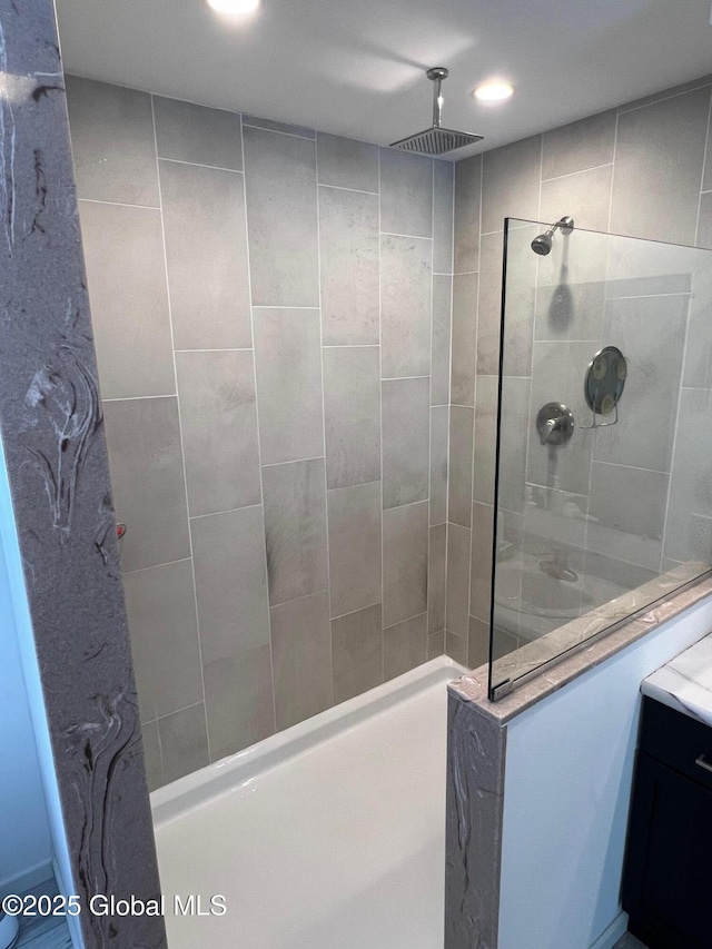 bathroom with recessed lighting, a walk in shower, and vanity