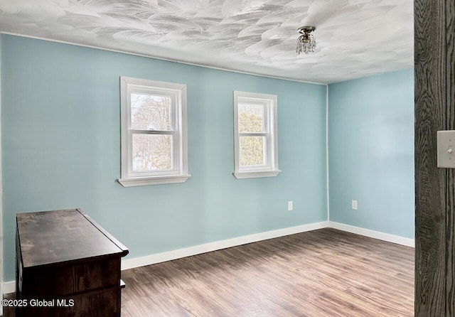 unfurnished room featuring baseboards and wood finished floors