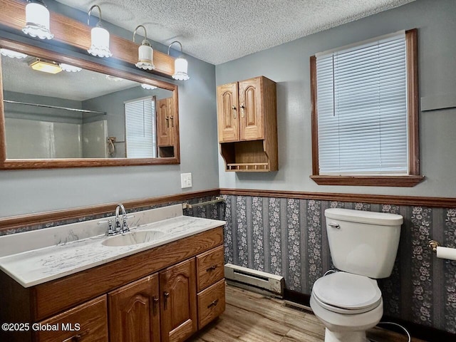 full bath featuring toilet, a wainscoted wall, a baseboard radiator, wood finished floors, and a textured ceiling