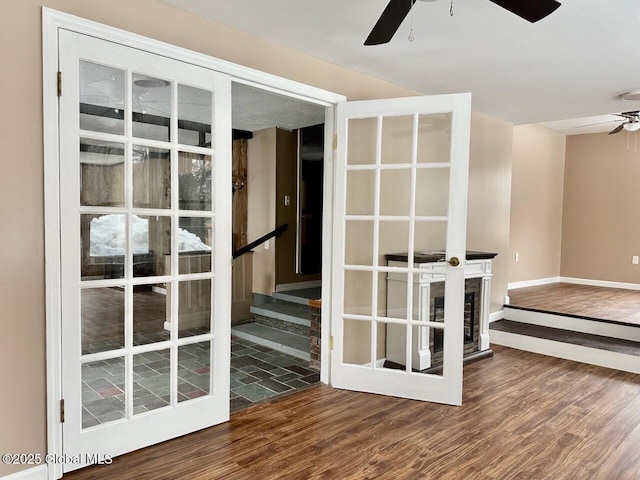 empty room with baseboards, a ceiling fan, and wood finished floors