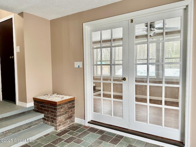 doorway featuring a ceiling fan, french doors, a textured ceiling, and baseboards