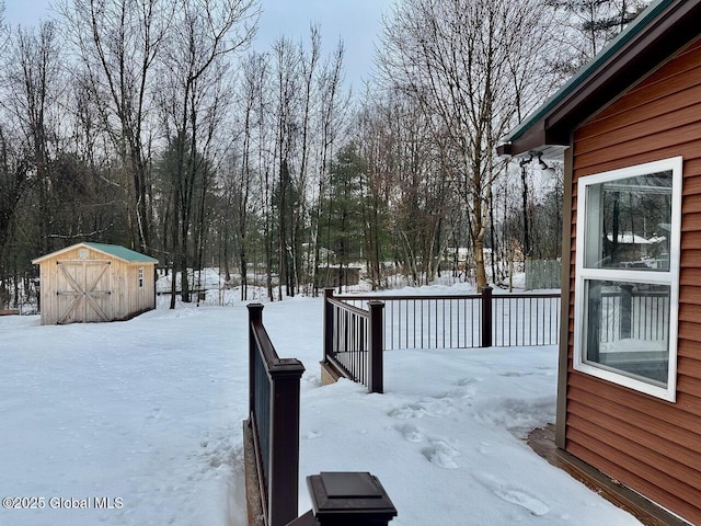 yard covered in snow featuring an outbuilding and a shed