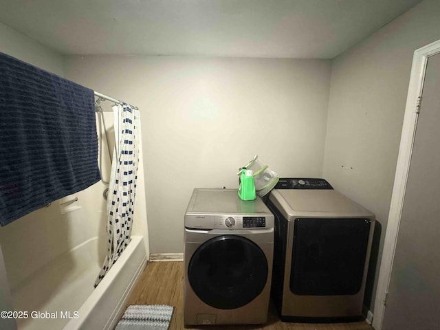 washroom featuring laundry area, light wood finished floors, and washing machine and dryer