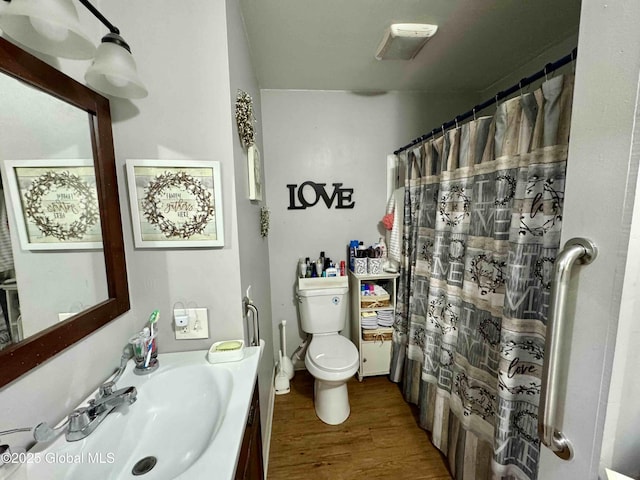 bathroom with vanity, wood finished floors, and toilet