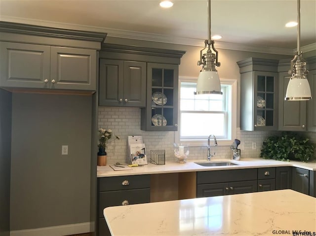 kitchen featuring glass insert cabinets, a sink, and gray cabinetry