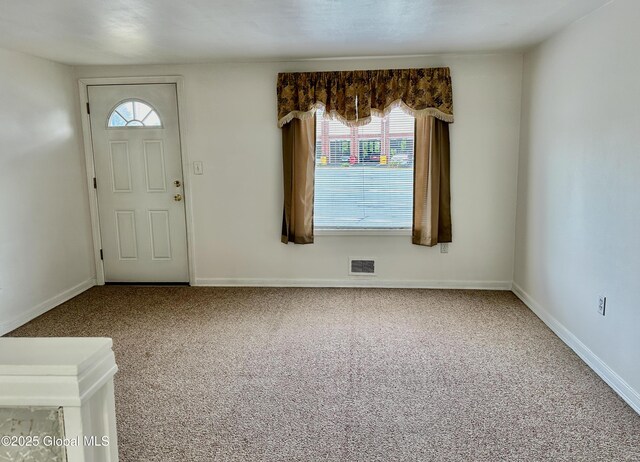 carpeted entryway featuring visible vents and baseboards