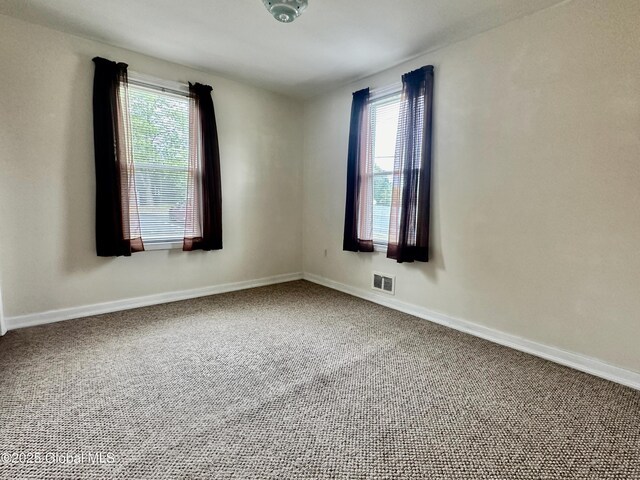 unfurnished room with carpet, baseboards, and visible vents