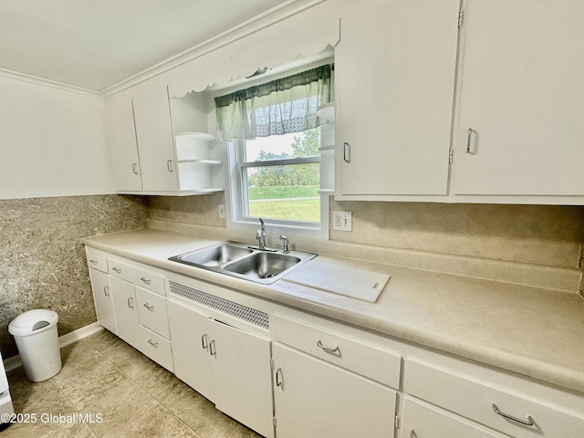 kitchen featuring a sink, open shelves, white cabinets, and light countertops