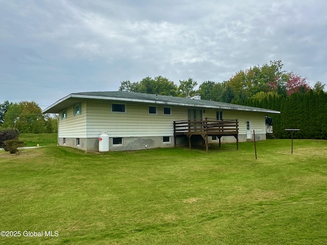 back of house featuring a lawn and a deck