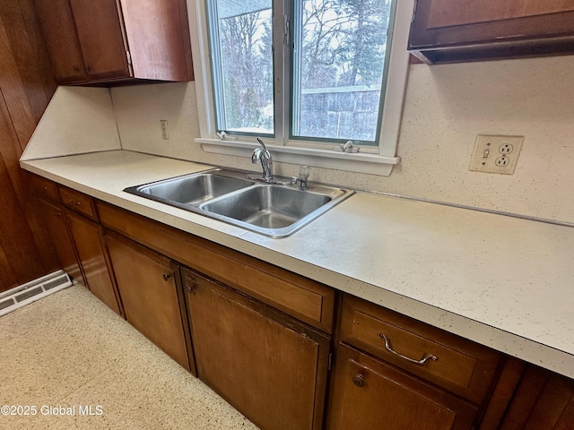 kitchen with a sink, visible vents, and light countertops