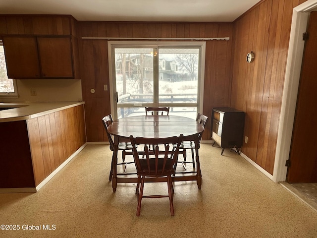 dining space featuring wood walls and baseboards