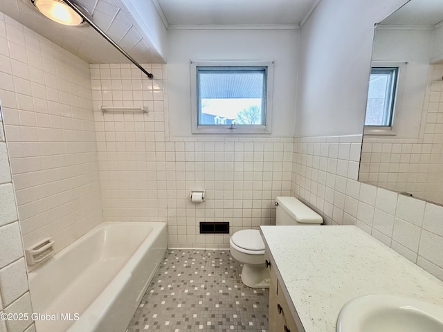 bathroom featuring tile walls, shower / washtub combination, toilet, ornamental molding, and vanity