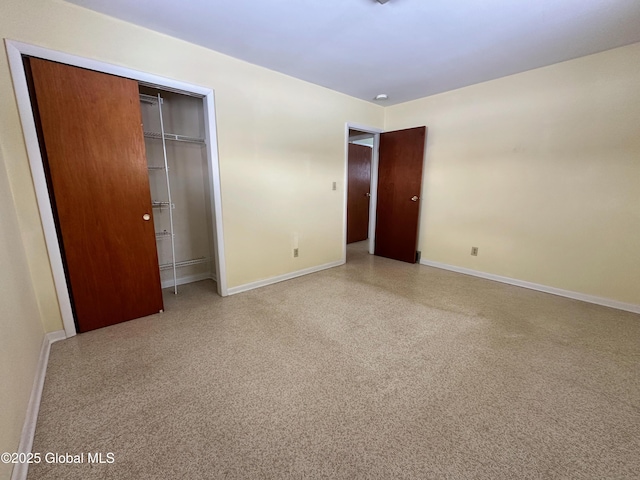 unfurnished bedroom featuring a closet, speckled floor, and baseboards