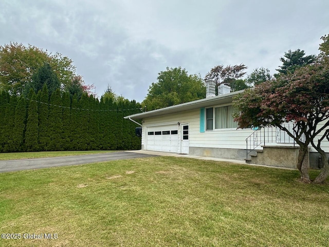 view of home's exterior featuring a yard, a chimney, and driveway