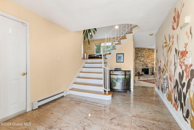 foyer entrance with a baseboard radiator, a fireplace, and stairway