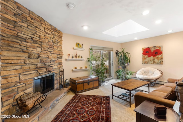 living area featuring a skylight, carpet, recessed lighting, a baseboard radiator, and a stone fireplace