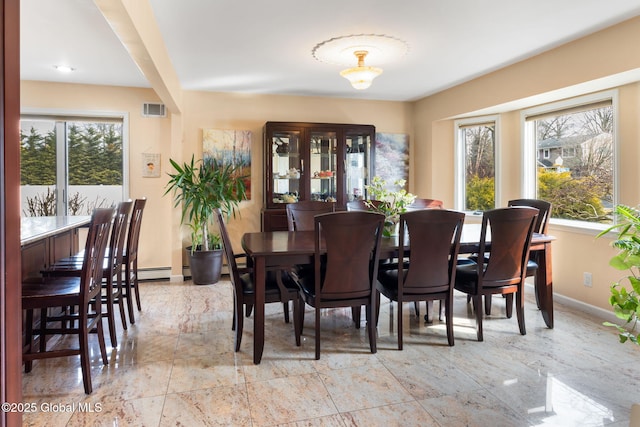 dining area with a healthy amount of sunlight, visible vents, and baseboards