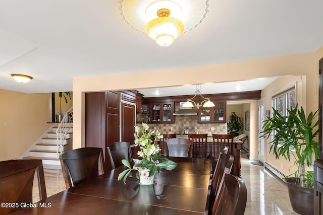 dining room with a baseboard heating unit, stairway, and a notable chandelier