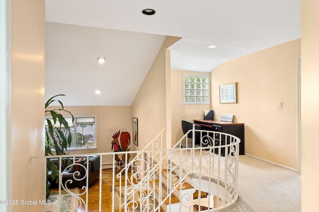 corridor featuring lofted ceiling, baseboard heating, baseboards, and recessed lighting