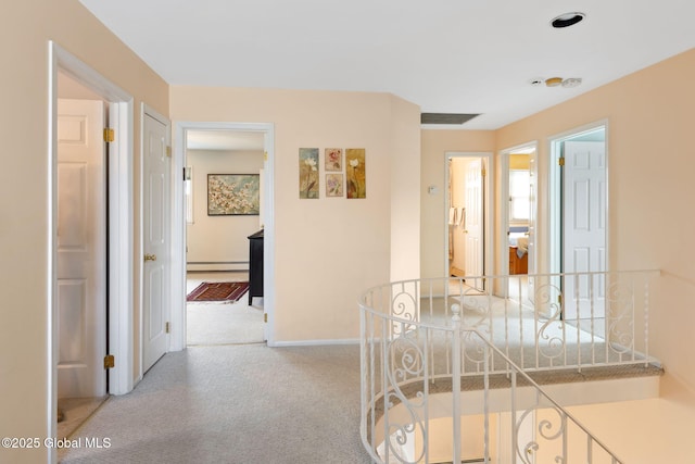 hallway with carpet floors, a baseboard radiator, baseboards, and an upstairs landing