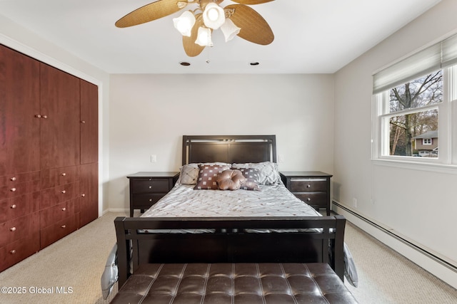 bedroom with carpet floors, a baseboard heating unit, and a ceiling fan