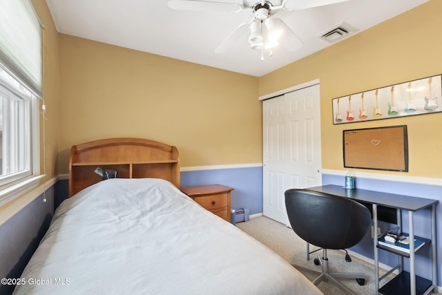 bedroom with a baseboard radiator, visible vents, carpet, and multiple windows