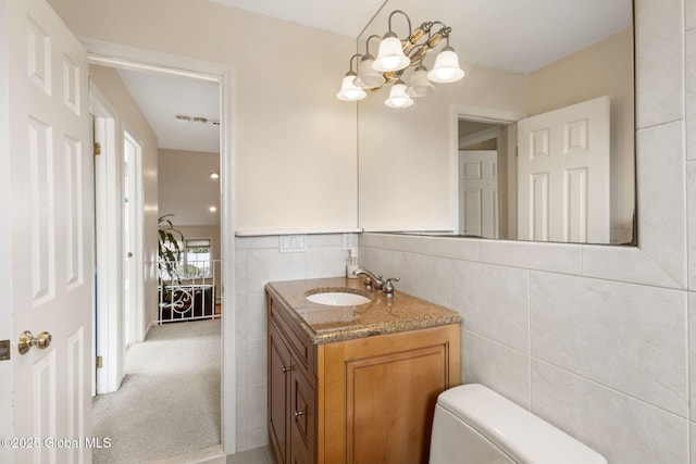 bathroom featuring toilet, tile walls, and vanity