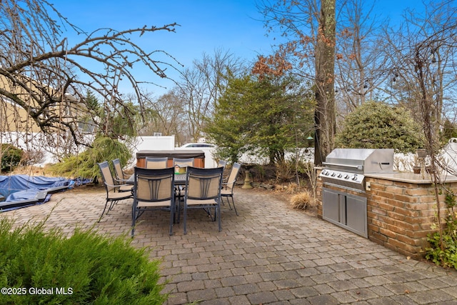 view of patio / terrace featuring outdoor dining area, fence, grilling area, and exterior kitchen