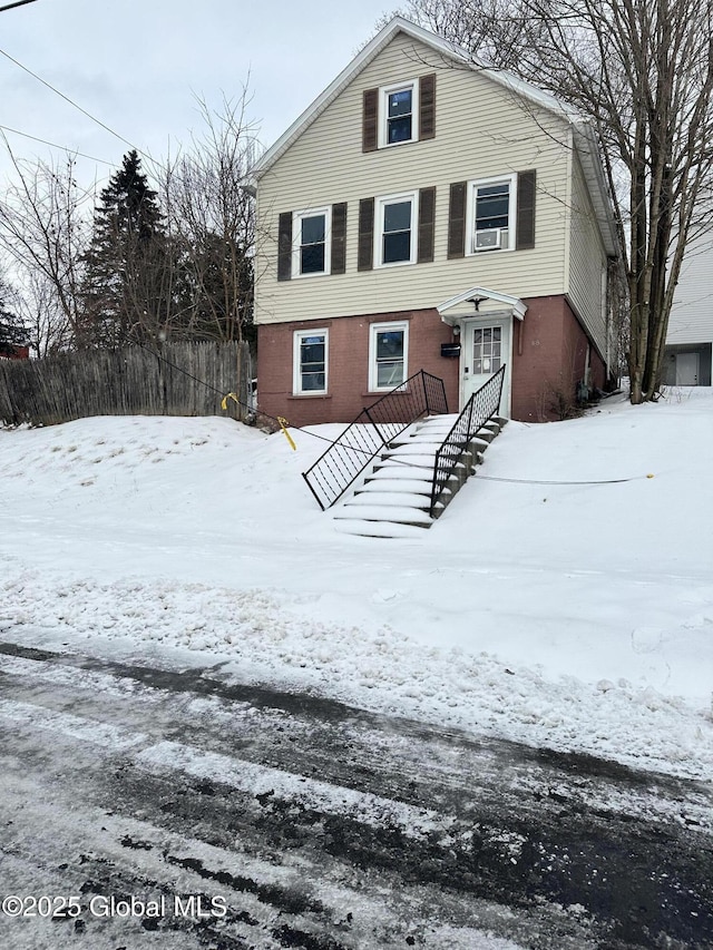 view of front of property with brick siding and fence