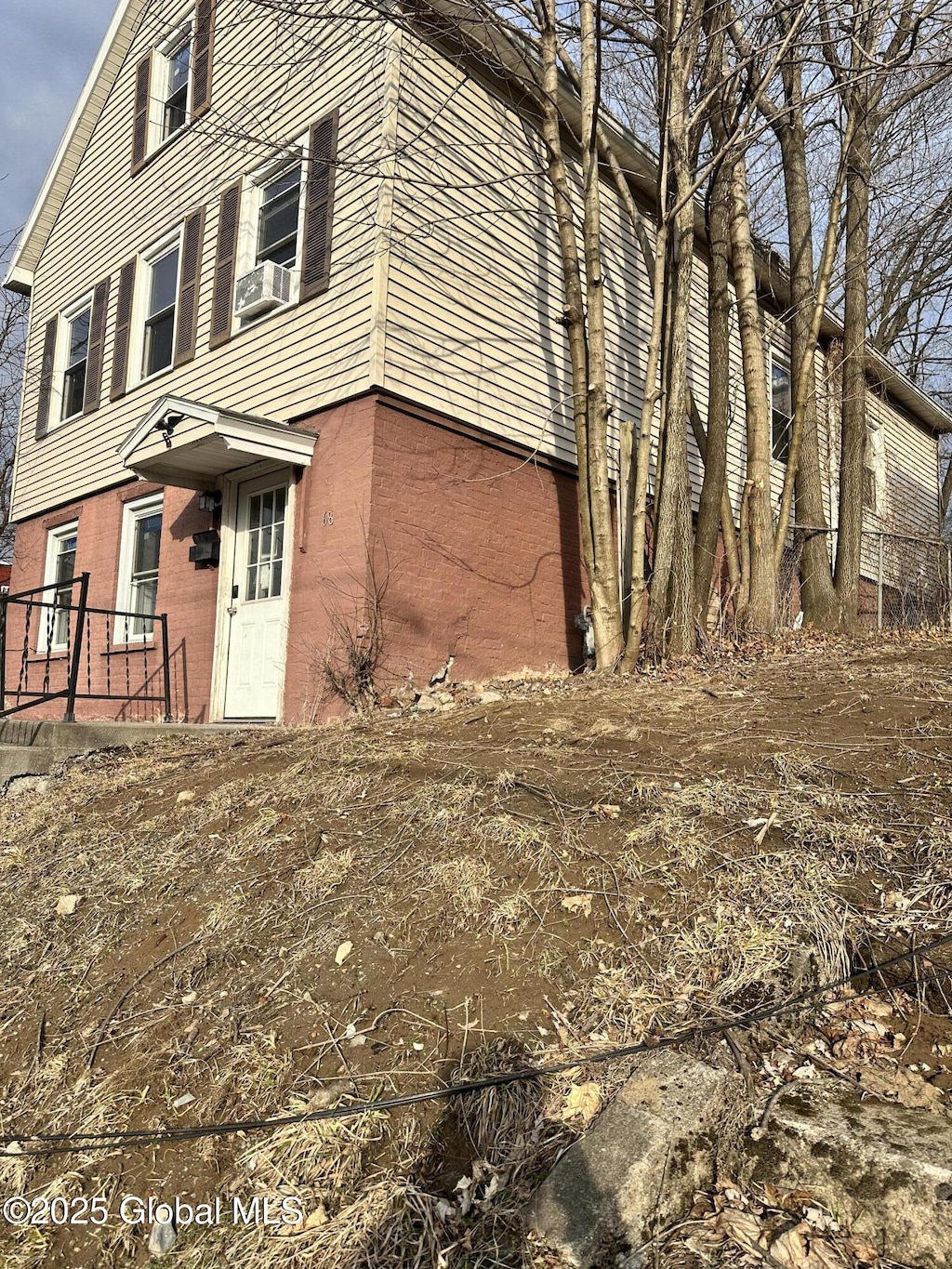 view of side of home with brick siding and cooling unit