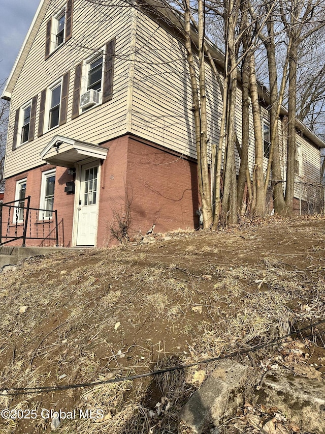 view of side of home with brick siding and cooling unit