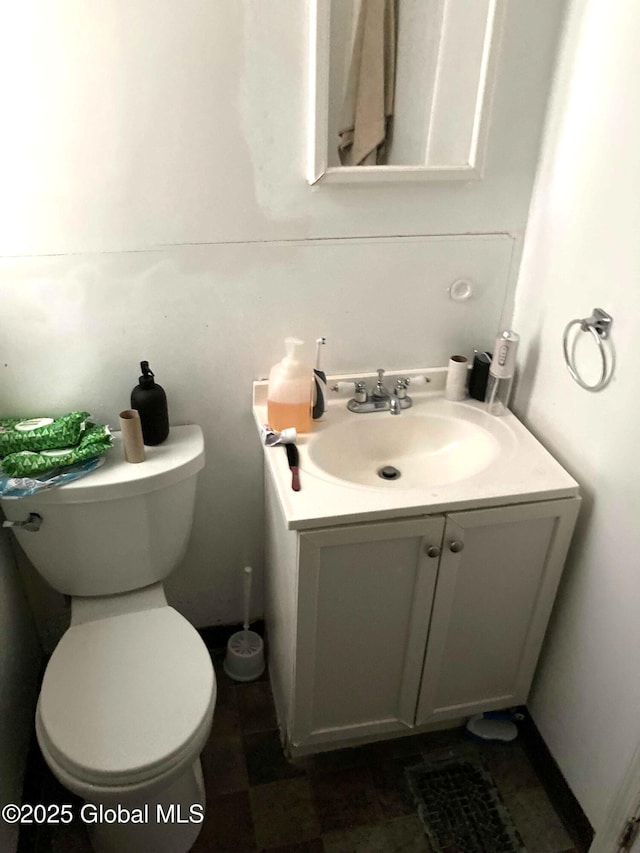 half bath featuring vanity and toilet