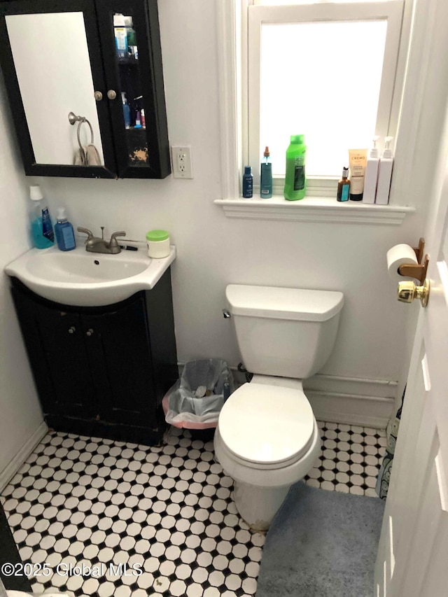 bathroom with baseboards, vanity, and toilet