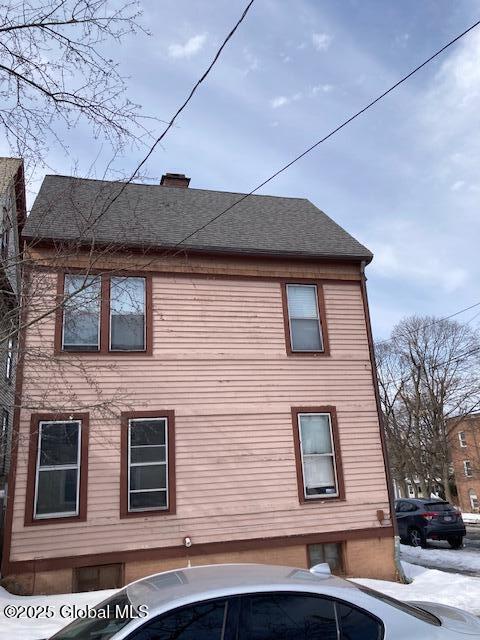 view of property exterior with a shingled roof