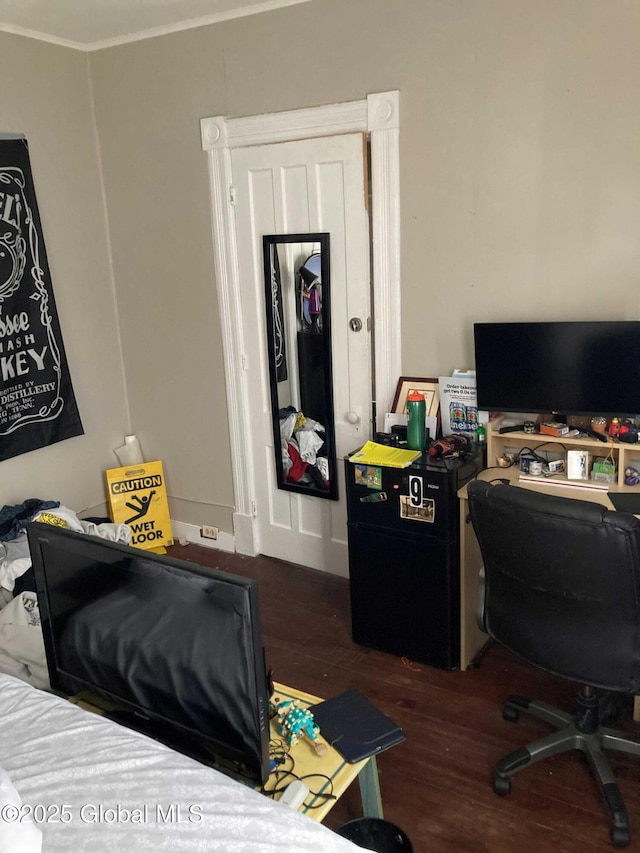 bedroom featuring ornamental molding and dark wood finished floors