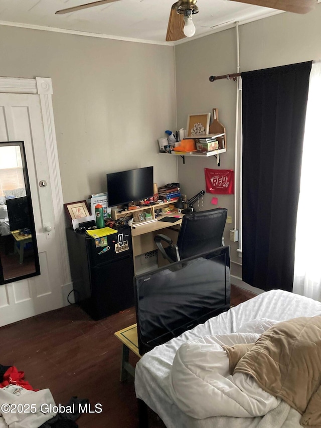 bedroom featuring ornamental molding, dark wood-style flooring, and freestanding refrigerator