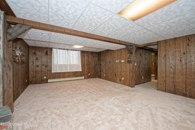 below grade area with a baseboard heating unit, wood walls, and carpet floors